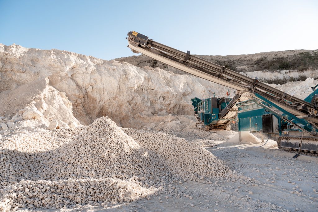 Industrial rock crusher at quarry site under sunlight